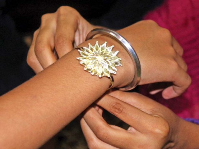 a girl ties a rakhi on her brother s wrist photo muhammad iqbal express a girl ties a rakhi on her brother s wrist photo muhammad iqbal express