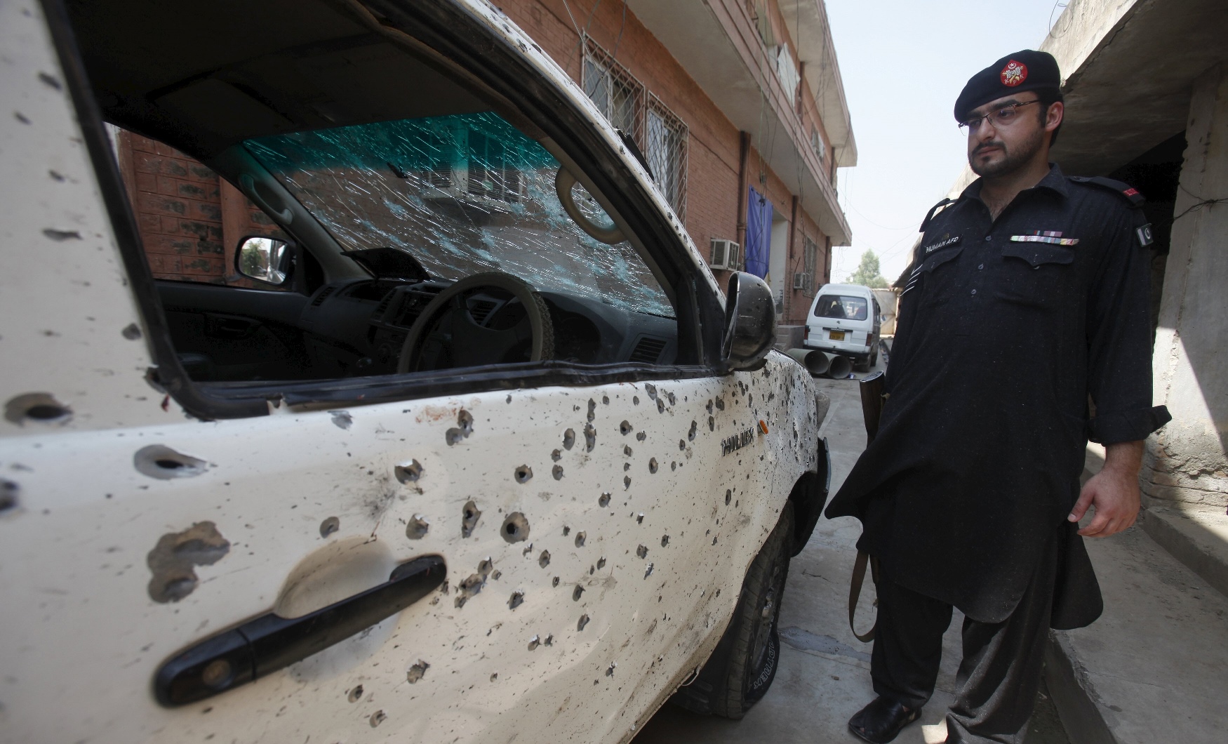 a security official stands next to a vehicle damaged in a suicide attack in jamrud pakistan september 1 2015 photo reuters