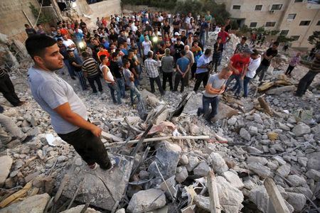 palestinians stand next to the rubble of a house which was destroyed by israeli troops during an israeli raid in the west bank city of jenin september 1 2015 photo reuters