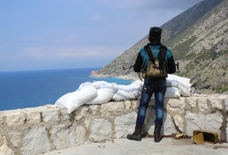 a rebel fighter from the ansar al sham brigade stands on a ridge overlooking the mediterranean sea reportedly in the village of kasab in the northwestern syrian province of latakia on april 4 2014 photo afp