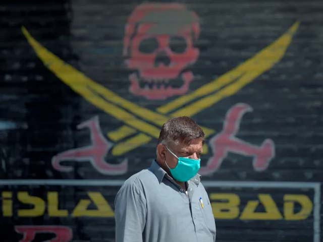 a pakistani man wearing a face mask walks past closed market shops in karachi photo getty a pakistani man wearing a face mask walks past closed market shops in karachi photo getty