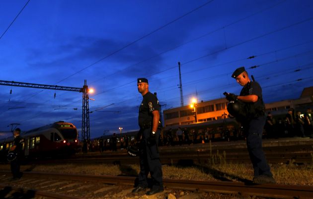 police guard a train full of refugees stuck in a stalemate as they refuse to obey police and get off at the station fearing they would be put up in a nearby refugee camp in bicske hungary september 3 2015 photo reuters