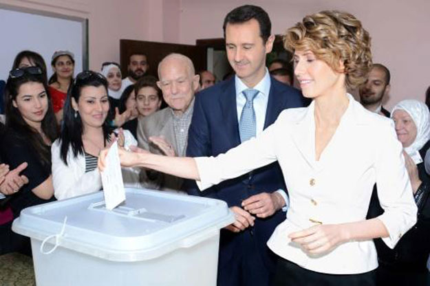 bashar al assad centre looks on as his wife asma casts her vote in syria 039 s presidential election at a polling station in maliki on june 3 2014 photo afp