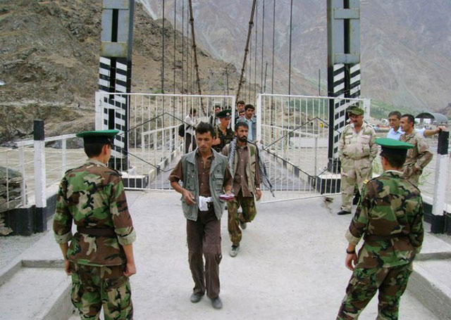a photo taken in august 2010 and made available on september 21 2010 shows tajik border guards checking identification documents of people crossing the tajik afghan border on a bridge across the panj river outside the city of panj photo afp