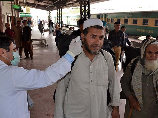 a health official checks the body temperature of a passenger at a railway station in peshawar photo getty