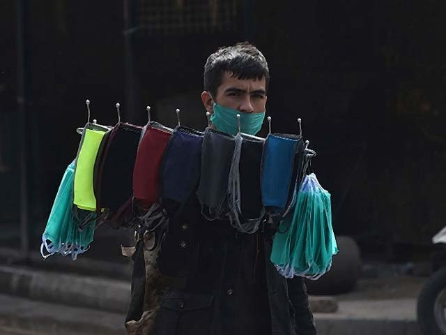 a vendor carries face masks for sale on a deserted street during a lockdown photo getty a vendor carries face masks for sale on a deserted street during a lockdown photo getty