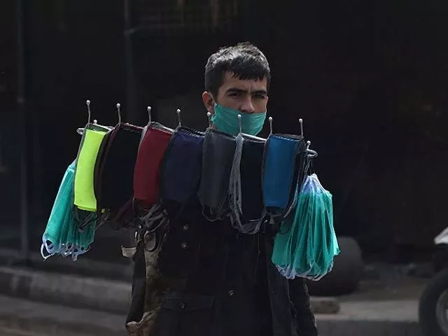 a vendor carries face masks for sale on a deserted street during a lockdown photo getty a vendor carries face masks for sale on a deserted street during a lockdown photo getty