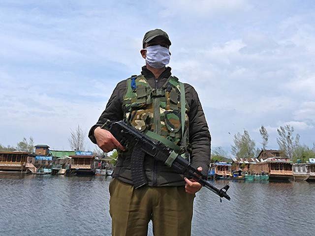 an indian policeman wearing a face mask stands guard at dal lake in srinagar photo getty