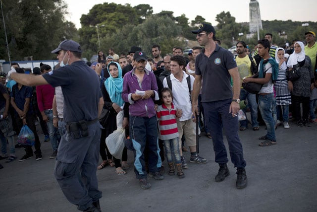 police direct migrants as they wait to be registered by the police at the lesbos port on september 4 2015 photo afp police direct migrants as they wait to be registered by the police at the lesbos port on september 4 2015 photo afp