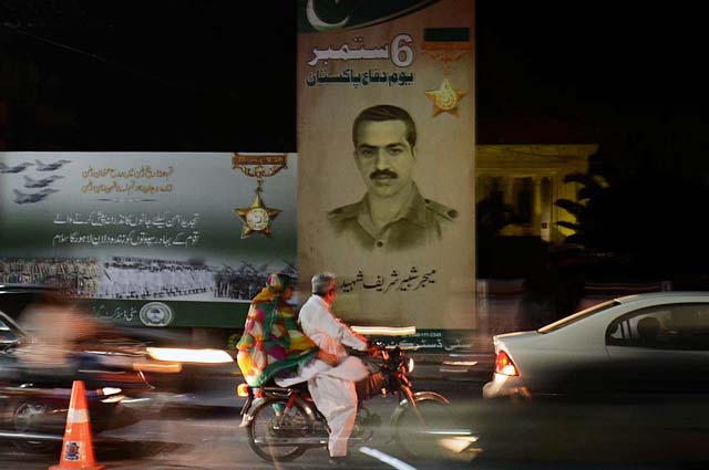 traffic passing by a signboard honouring featuring major shabbir sharif nishan e haider in lahore photo online