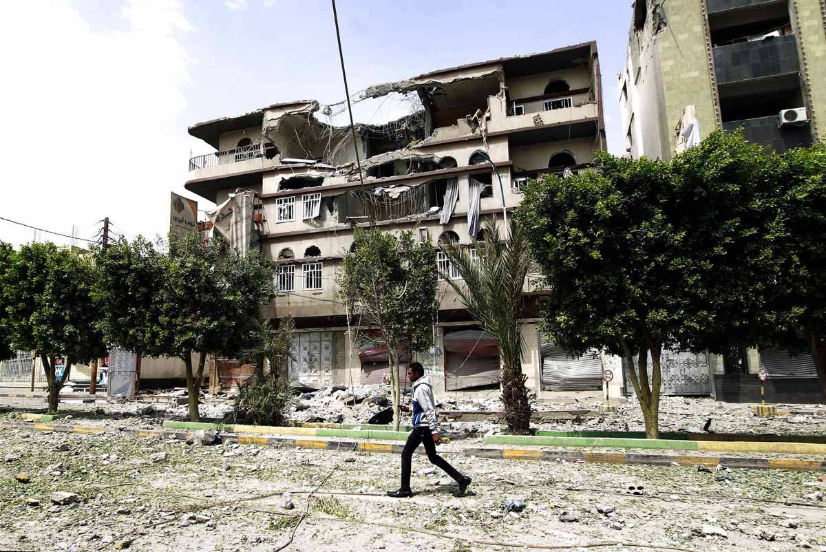 a yemeni man walks past damaged buildings following an air strike by the saudi led coalition in the capital sanaa on september 5 2015 photo afp