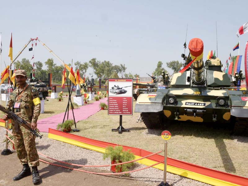 a soldier stands guard in front of a tank in a defence day exhibition in peshawar photo afp