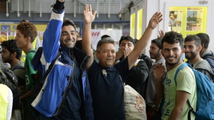 in munich refugee families holding their children and few belongings smiled as they were greeted with cheers food and water bottles by crowds late saturday photo afp