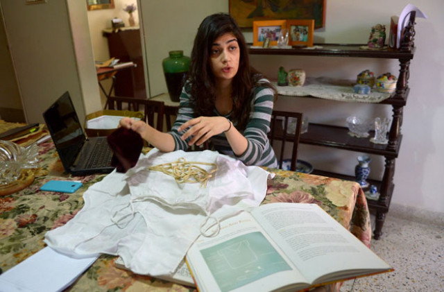 veena rustomji displays clothing to be used in prayers in karachi photo afp veena rustomji displays clothing to be used in prayers in karachi photo afp