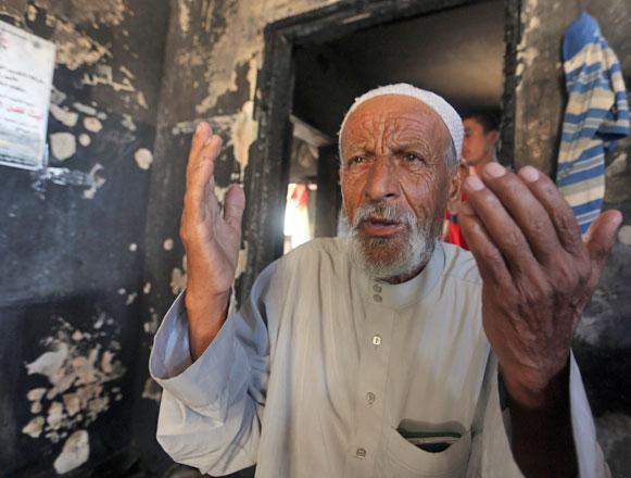 mohammed the father of saad dawabsheh a palestinian man who was killed alongside his toddler when their house was firebombed by jewish extremists on july 31 prays at the family s burnt out home in the west bank village of duma the day after his son s funeral photo afp