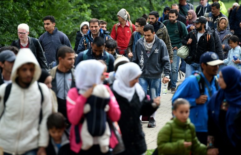 migrants walk to get a bus after their arrival at the train station in dortmund western germany on september 6 2015 photo afp