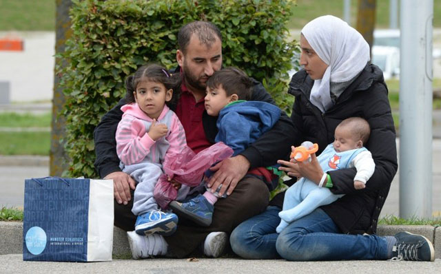 a refugee family from syria waits in front of a exhibition hall at the munich fairground that serves as makeshift shelter for migrants after they arrived in munich southern germany september 07 2015 photo afp