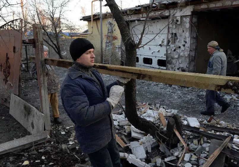 local residents repair the fence next to their home after it was wrecked by shelling in donetsk on february 12 2015 photo afp local residents repair the fence next to their home after it was wrecked by shelling in donetsk on february 12 2015 photo afp
