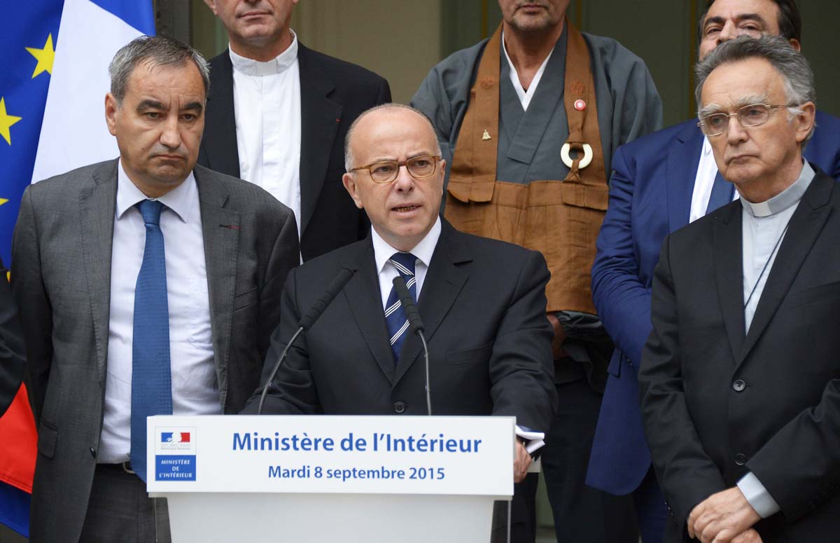 french interior minister bernard cazeneuve delivers a speech flanked by religious representatives after a round table talks in paris on september 8 2015 photo afp