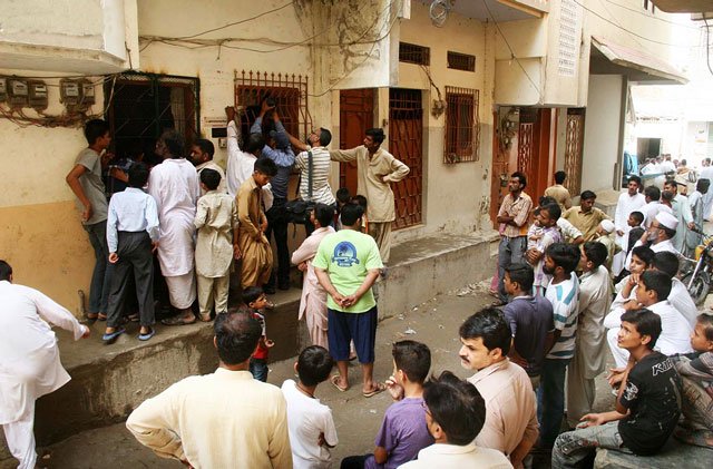 people gather outside a house in karachi s manzoor colony area where bodies of four family members were found on wednesday september 09 2015 photo online