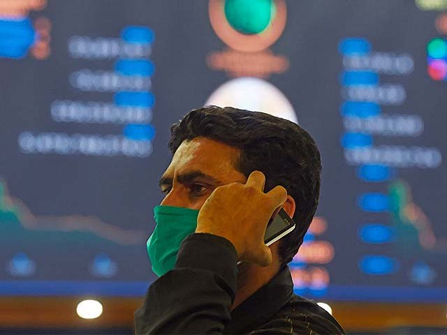 a stockbroker wearing a face mask holds a mobile phone during a trading session photo getty a stockbroker wearing a face mask holds a mobile phone during a trading session photo getty