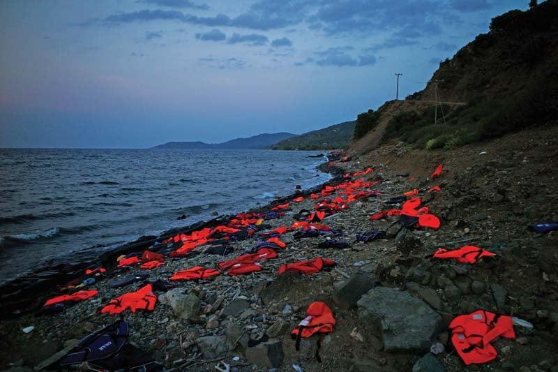 a view of the greek island of lesbos shows life vests left on the shore by incoming refugees photo afp