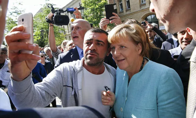 a migrant takes a selfie with german chancellor angela merkel outside a refugee camp near the federal office for migration and refugees after registration at berlin 039 s spandau district germany september 10 2015 photo reuters a migrant takes a selfie with german chancellor angela merkel outside a refugee camp near the federal office for migration and refugees after registration at berlin 039 s spandau district germany september 10 2015 photo reuters