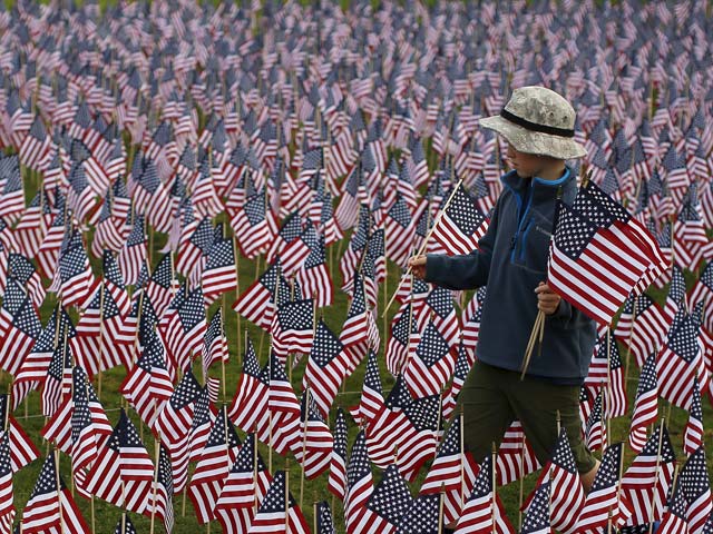 a boy walks among some of the 3 000 flags placed in memory of the lives lost in the september 11 2001 attacks at a park in winnetka illinois september 10 2015 photo reuters