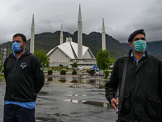 policemen wearing face masks stand guard at a checkpoint beside the grand faisal mosque during a government imposed nationwide lockdown photo getty policemen wearing face masks stand guard at a checkpoint beside the grand faisal mosque during a government imposed nationwide lockdown photo getty