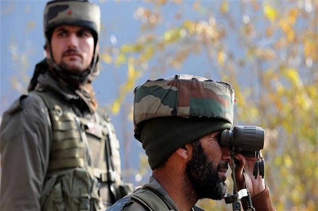 indian soldiers look on from their position by a road overlooking army barracks in gingal uri some 90 kms north of srinagar on december 5 2014 photo afp