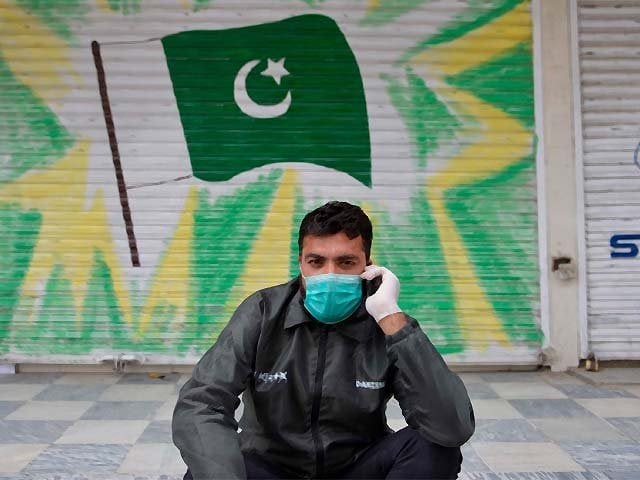 a man wearing a face mask sits in front of a shuttered market during a government imposed nationwide lockdown photo afp
