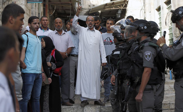 palestinians shout slogans in front of israeli security forces who block a road leading to the al aqsa mosque compound in jerusalem 039 s old city on september 13 2015 palestinians clashed with israeli police at al aqsa mosque compound just hours before the start of the jewish new year photo afp