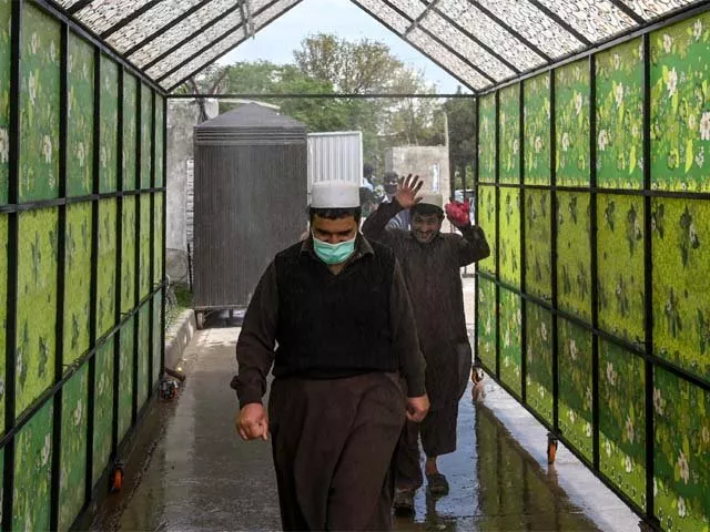residents wearing face masks walk through a disinfecting tunnel in islamabad photo afp residents wearing face masks walk through a disinfecting tunnel in islamabad photo afp