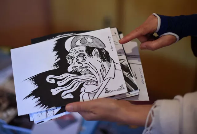 afghan woman satire masouda khazan tokhi 39 displays a cartoon paper as she works on a satirical piece inside of her home in kabul photo afp afghan woman satire masouda khazan tokhi 39 displays a cartoon paper as she works on a satirical piece inside of her home in kabul photo afp