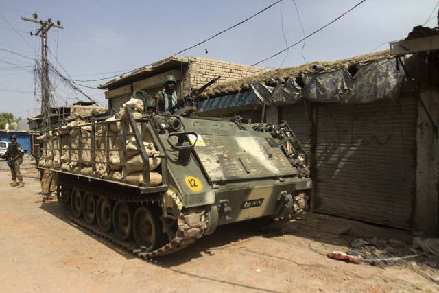 a soldier stands in an armoured vehicle during a military operation against taliban militants in the town of miranshah in north waziristan july 9 2014 photo reuters