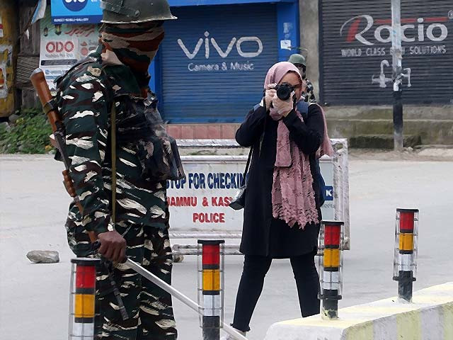 photojournalist masrat zahra takes photos near a temporary checkpoint before going to the cyber police station in srinagar kashmir photo afp