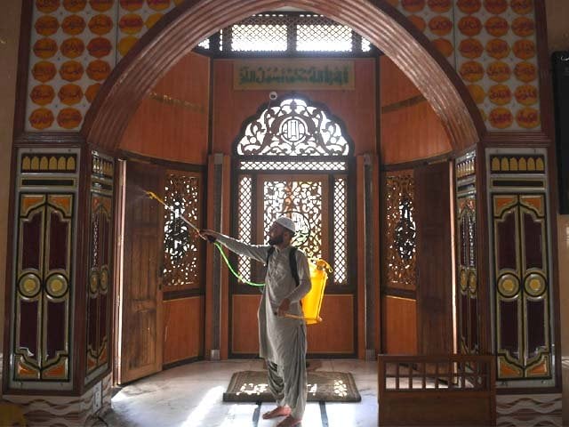 a muslim devotee sprays disinfectant in a mosque ahead of the muslim holy month of ramazan photo afp
