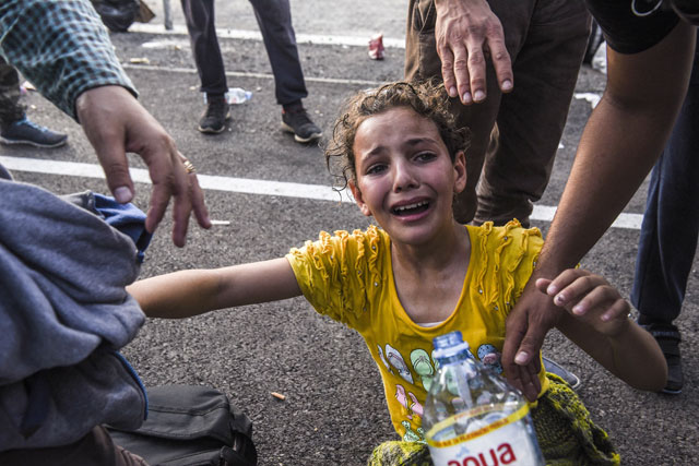 a girl reacts after receiving tear gas during clashes between migrants and hungarian anti riot police at the hungarian border with serbia near the town of horgos on september 16 2015 photo afp