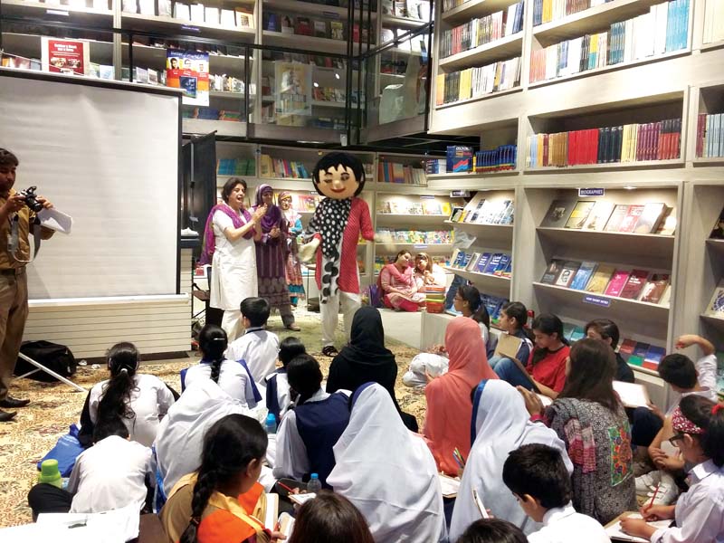 cartoonist gives demonstration to school children about making cartoons on social issues photo mariam shafqat