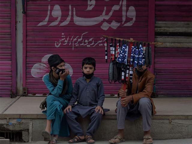 children selling face masks wait for customers at a closed market area in rawalpindi photo afp