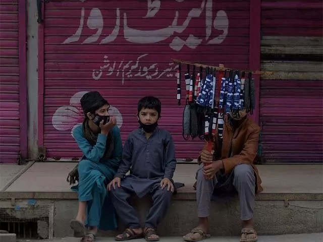 children selling face masks wait for customers at a closed market area in rawalpindi photo afp children selling face masks wait for customers at a closed market area in rawalpindi photo afp