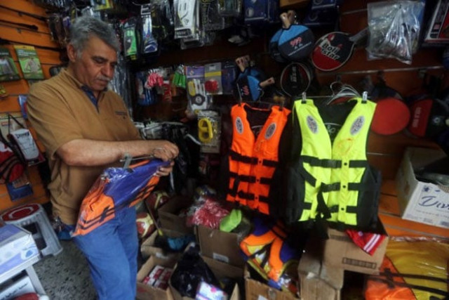 an iraqi man arranges life jackets at his shop on rashid street where many of the baghdad s sports shops are located on september 13 2015 as demand for the survival vests has peaked with the increasing number of iraqis trying to reach europe by boat smugglers may not provide enough life jackets and while estimates of costs vary they are said to be much cheaper in iraq than in turkey where the journey by boat to greece begins photo afp