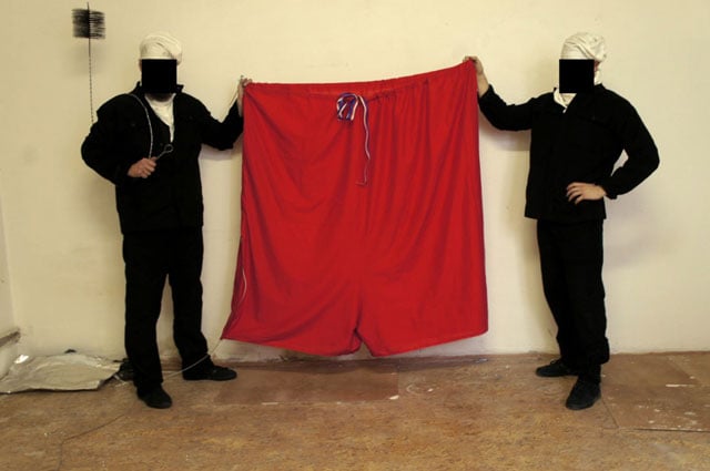 this handout photo made available by art provocateur group ztohoven shows their two members dressed as chimney sweeps holding the oversized red underwear on september 19 2015 at the prague castle in the czech capital photo afp