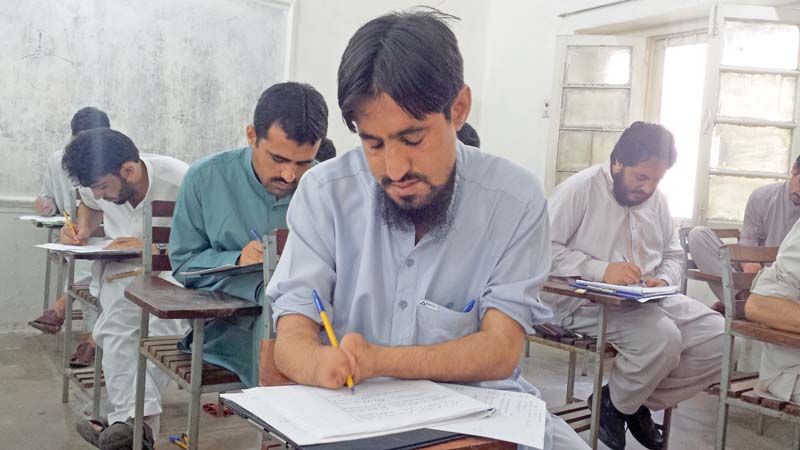 a picture of abdul malik while he takes notes in class photo express