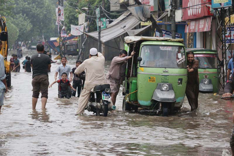 motorists wade through rain water at lakshmi chowk photo shafiq malik express