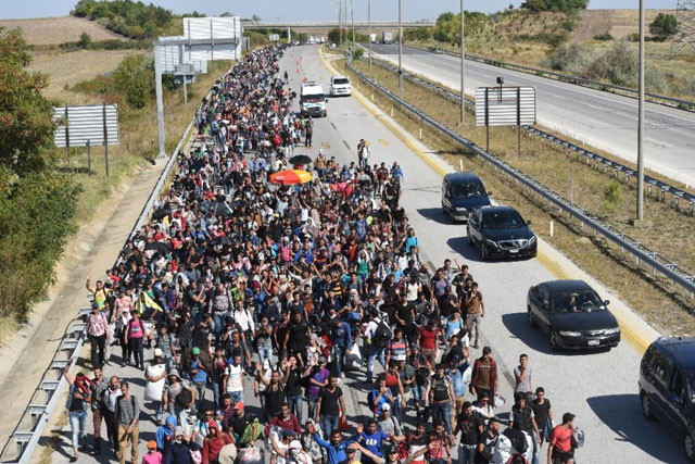 syrian migrants and refugees march towards greece along a highway on september 18 2015 on their way to the border between turkey and greece photo afp