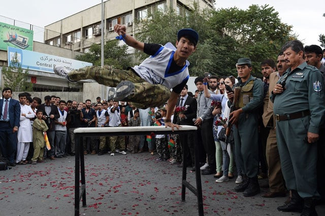 an afghan practitioner of parkour demonstrates his skills as spectators watch during a street concert to campaign for peace in the city of kabul on september 21 2015 photo afp an afghan practitioner of parkour demonstrates his skills as spectators watch during a street concert to campaign for peace in the city of kabul on september 21 2015 photo afp