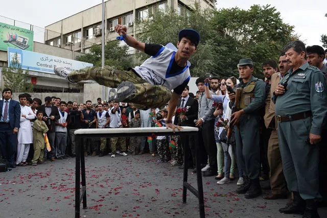 an afghan practitioner of parkour demonstrates his skills as spectators watch during a street concert to campaign for peace in the city of kabul on september 21 2015 photo afp an afghan practitioner of parkour demonstrates his skills as spectators watch during a street concert to campaign for peace in the city of kabul on september 21 2015 photo afp