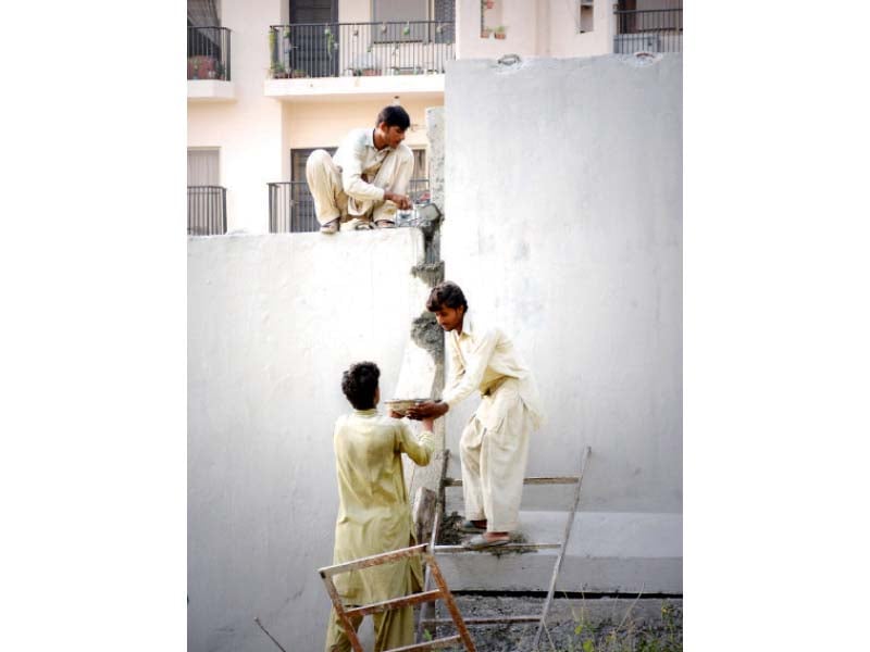 the labourers are constructing the jersey barrier along margalla road in islamabad as part of the safe city project being launched by the government photos huma choudhary express