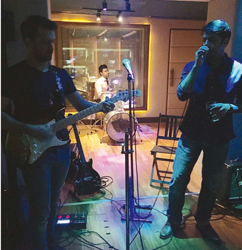 atif aslam on guitars farhan saeed on drums and goher mumtaz on vocals at ali zafar s studio in lahore photo publicity